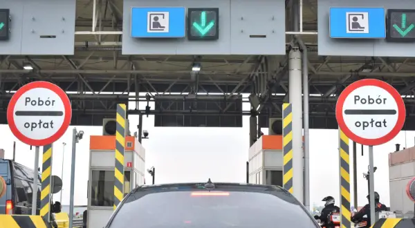 Bramki poboru opłat na autostradzie z samochodami i motocyklami w kolejce.